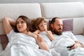 Sad offended family Mother father and daughter lie in bed after quarrel. Disagreements and quarrels in the family. Upset Royalty Free Stock Photo