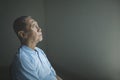 Sad old man daydreaming in the dark room Royalty Free Stock Photo