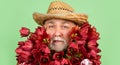 sad old retired man in straw hat hold spring tulip flowers on green background Royalty Free Stock Photo