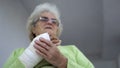 Sad senior woman having pain sitting and holding her injured hand in bandages Royalty Free Stock Photo