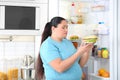 Sad overweight woman taking sandwich from refrigerator Royalty Free Stock Photo