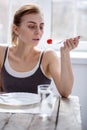 Sad pale woman looking at the tomato