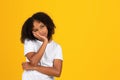 Sad pensive tired adolescent curly girl in white t-shirt looks at empty space, think