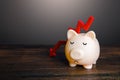 Sad piggy bank and arrow down. Difficult economic situation. Expenditure of savings and financial reserves. Falling income, lower Royalty Free Stock Photo