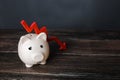 Sad piggy bank and down arrow. Savings and reserves decrease. Inflation, depreciation of assets. Falling income, lower wages. Royalty Free Stock Photo