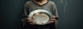 a sad poor boy holding a empty plate. hunger concept. poverty child. beggar, begging.