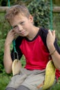 Sad pre-teen boy sitting on a swing Royalty Free Stock Photo