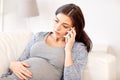 Sad pregnant woman calling on smartphone at home Royalty Free Stock Photo