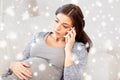 Sad pregnant woman calling on smartphone at home Royalty Free Stock Photo