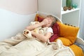 Sad preteen girl crying in bed holding toy, unhappy sick child feeling lonely