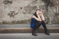 Sad pretty girl sitting on sidewalk Royalty Free Stock Photo