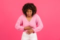 Sad pretty young black curly woman in casual suffering from stomach hurt, menstrual pain Royalty Free Stock Photo