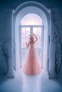 Sad princess looking window staying home. Queen lady enjoy evening sunset. concept freedom. long blonde hair.