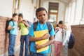 Sad pupil being bullied by classmates at corridor Royalty Free Stock Photo