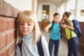 Sad pupil being bullied by classmates at corridor Royalty Free Stock Photo