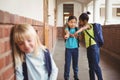 Sad pupil being bullied by classmates at corridor Royalty Free Stock Photo
