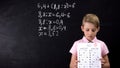 Sad pupil holding failed test against blackboard background, lack of knowledge