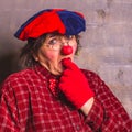 Sad and puzzled clown in glasses with red nose and glovesÃÂ± facial expression Royalty Free Stock Photo