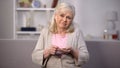 Sad retired lady looking camera holding coins hand, economic crisis, bankruptcy Royalty Free Stock Photo