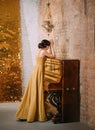 Sad retro woman near piano hide face and pray. finger wave hairstyle. gold dress Royalty Free Stock Photo