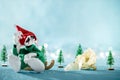 Sad Santas Helper Elf Sitting on Sledge Looking At Broken Christmas Bauble. North Pole Christmas Scene. Santas Workshop. Royalty Free Stock Photo