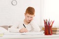 Sad schoolboy doing homework at home alone Royalty Free Stock Photo