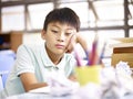 Sad schoolchild sitting alone in classroom Royalty Free Stock Photo