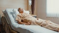 Sad senior Asia man having having heart attack lying on hospital bed and press emergency button. Sick aged guy lying hospitalized Royalty Free Stock Photo