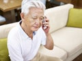 Sad senior asian man talking on cellphone Royalty Free Stock Photo