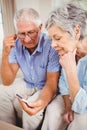 Sad senior couple looking at mobile phone Royalty Free Stock Photo