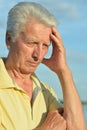 Sad senior man against blue cloudy sky Royalty Free Stock Photo