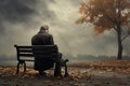 Sad senior man sitting alone on a bench in city park on autumn day. Elderly man enjoying nice fall weather