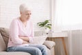 Sad senior woman holding her abdomen, suffering from stomach pain Royalty Free Stock Photo