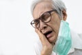 Sad senior woman holding her hand on her aching tooth,asian elderly suffering from toothache and tooth decay,old people having