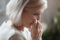 Sad senior woman mourning crying wiping tears grieving lost love