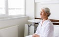 Sad senior woman sitting on bed at hospital ward Royalty Free Stock Photo