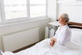 Sad senior woman sitting on bed at hospital ward Royalty Free Stock Photo