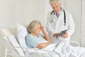 Portrait of sad senior woman in hospital with caring doctor Royalty Free Stock Photo