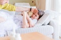 A sad, sick boy hugs a teddy bear. Caring dad checks for fever. Royalty Free Stock Photo