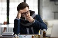 Sad sick office worker, businessman, manager wrapped in warm scarf Royalty Free Stock Photo