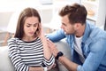 Sad sick woman sitting on the couch with her boyfriend Royalty Free Stock Photo