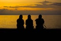 Sad Siluet people on sunset background, Silhouette three women sitting on the beach at Sunset Royalty Free Stock Photo