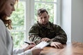 Sad soldier with depression and war syndrome during therapy with psychiatrist