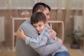 Sad son hugging his dad indoor Royalty Free Stock Photo