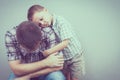 Sad son hugging his dad near wall Royalty Free Stock Photo