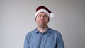 The sad and sorrowful European young man in a New Year's hat looks gloomily into the camera. Royalty Free Stock Photo