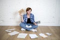 Sad stressed woman with calculator and bank and bills paperwork and documents doing domestic financial accounting