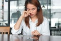 Sad stressed young Asian woman listening music with headphones in living room Royalty Free Stock Photo