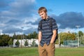 Sad student standing in a park.