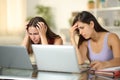 Sad students checking grades on laptops at home Royalty Free Stock Photo